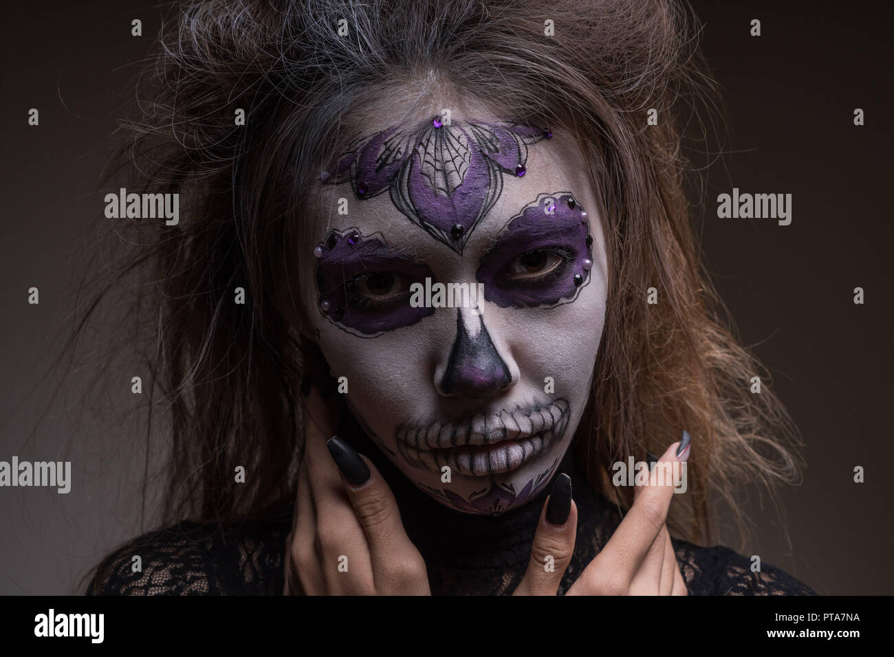 Portrait d'une fille avec un masque peint d'une personne morte sur son visage. Halloween de Banque D'Images