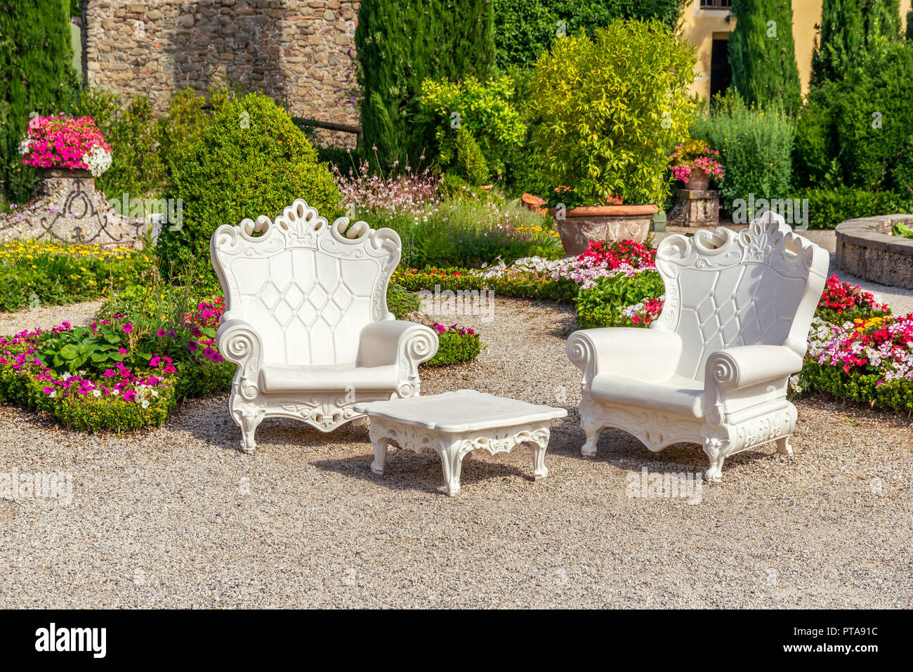 Photo horizontale de l'été en scène Garzoni jardin en Toscane avec de grands fauteuils en plastique blanc. Les chaises sont sur place avec du gravier coloré plusieurs f Banque D'Images
