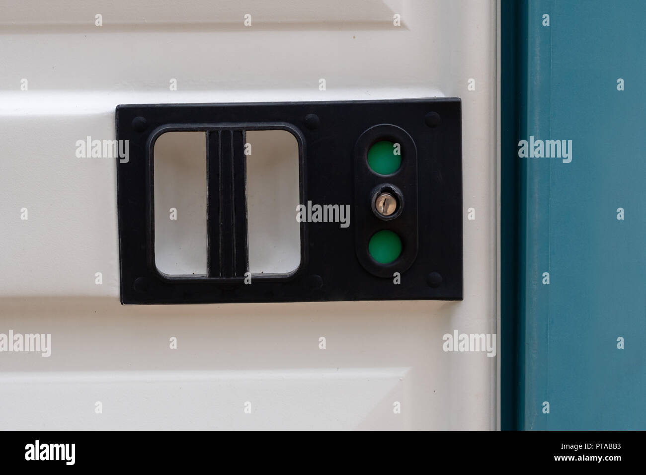 Close-up d'une serrure de porte des toilettes portables avec panneau vert Banque D'Images