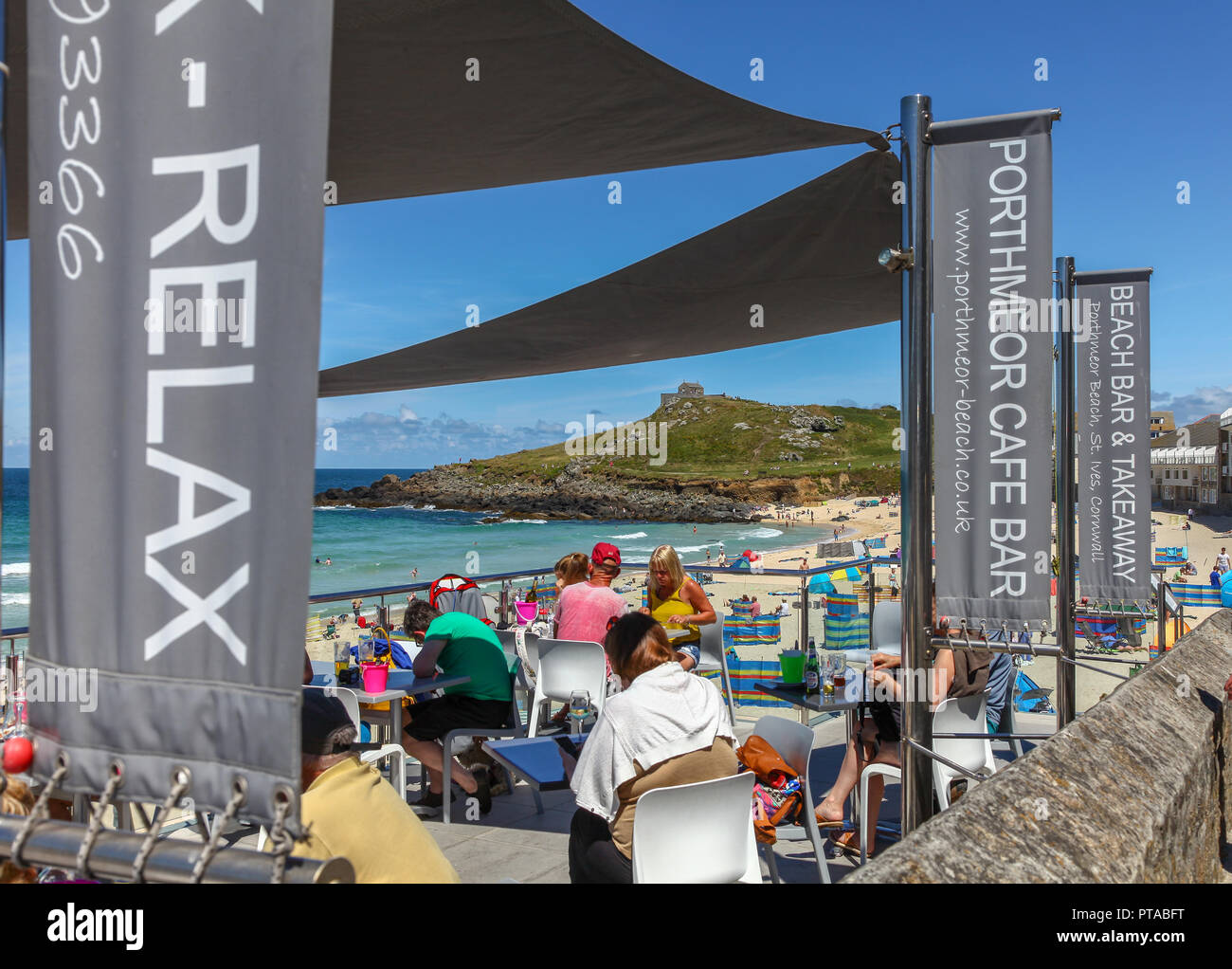 Les personnes assises et se détendant à manger et à boire au café-bar Porthmeor sur la plage de Porthmeor, St. Ives, Cornwall, Angleterre, Royaume-Uni Banque D'Images