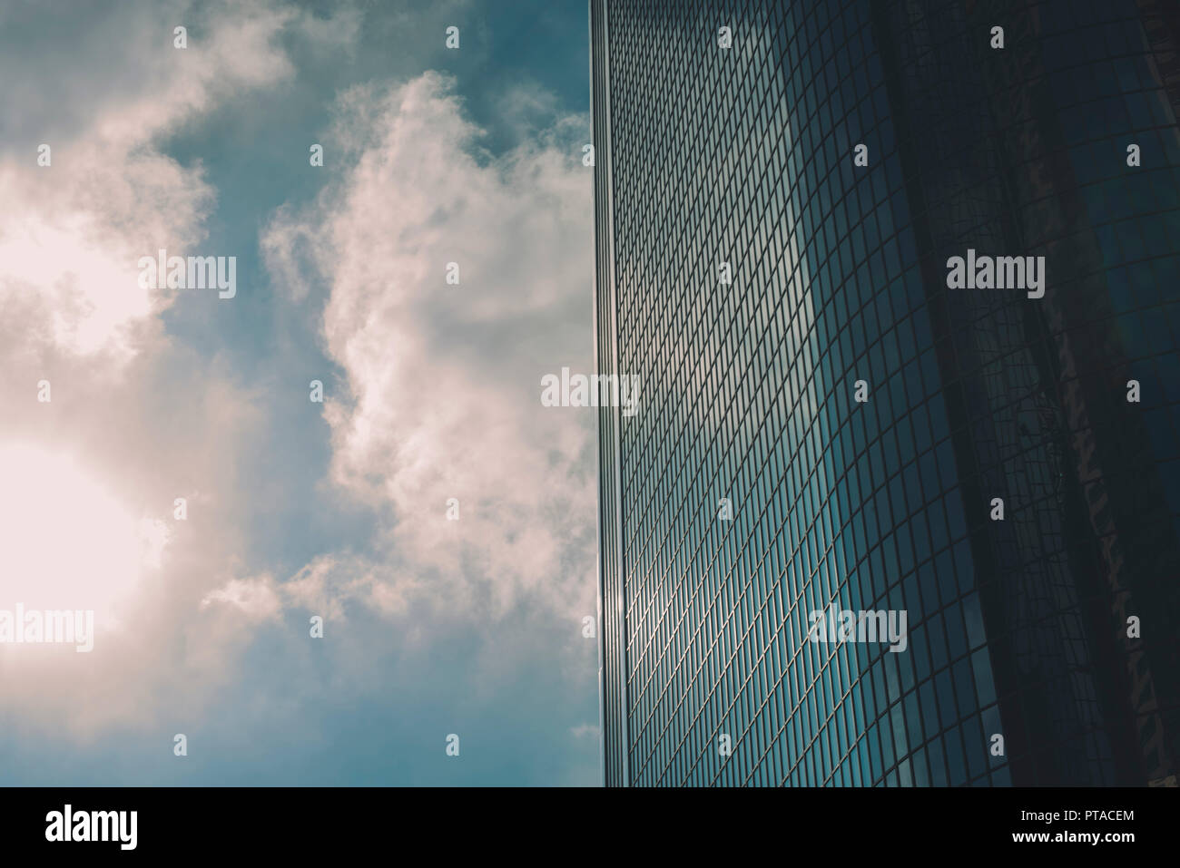 Le soleil, ciel bleu et nuages avec un racleur de ciel de verre Banque D'Images