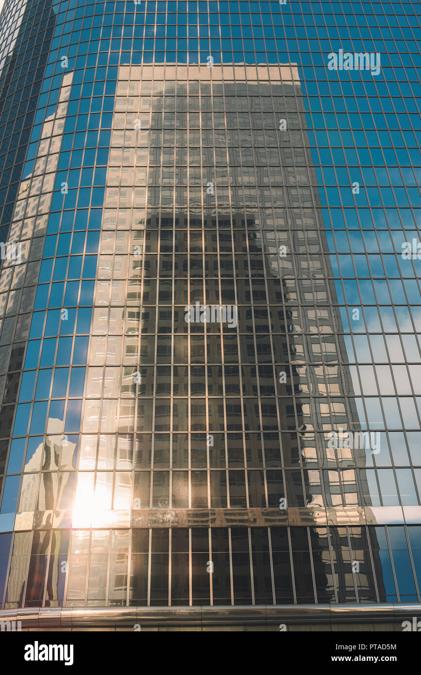 Un racleur de ciel de la ville se reflète sur un édifice de verre Banque D'Images