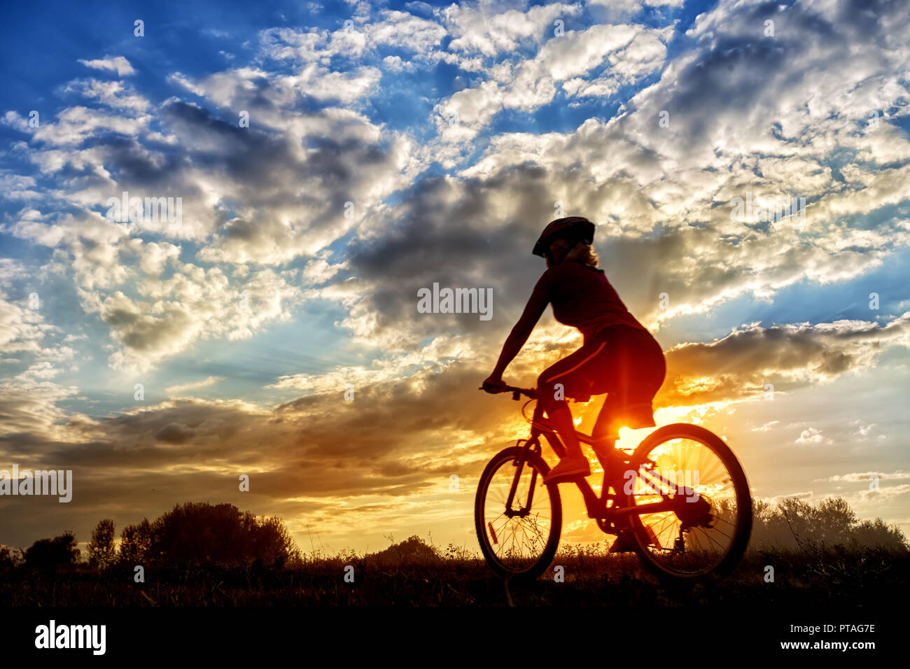 Silhouette d'une fille de rouler à vélo sur l'arrière-plan du soleil couchant. Paysage d'été. Le concept de liberté, de voyage et de mode de vie sain Photo Stock - Alamy