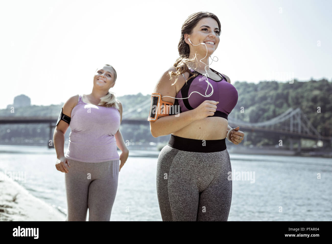 Femme active joyeuse ayant un jogging Banque D'Images
