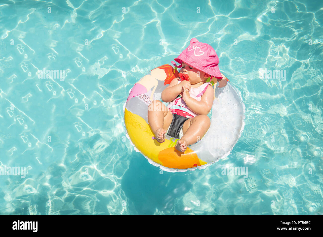 Cute Baby Girl Sleeping On flotter dans l'eau bleue des Caraïbes sur belle journée ensoleillée Banque D'Images