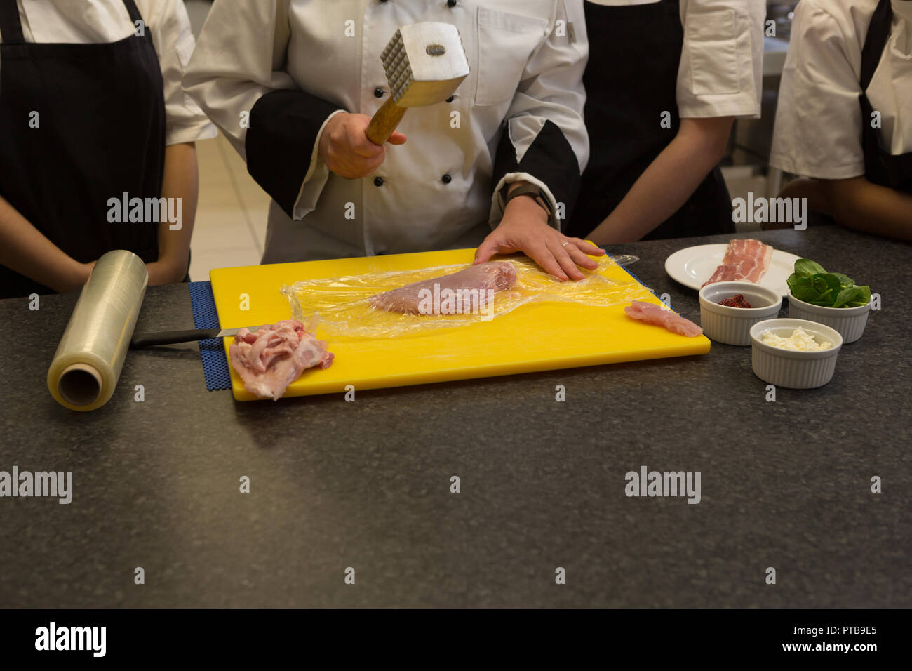 Chef cuisinier avec attendrisseur dans la cuisine Banque D'Images