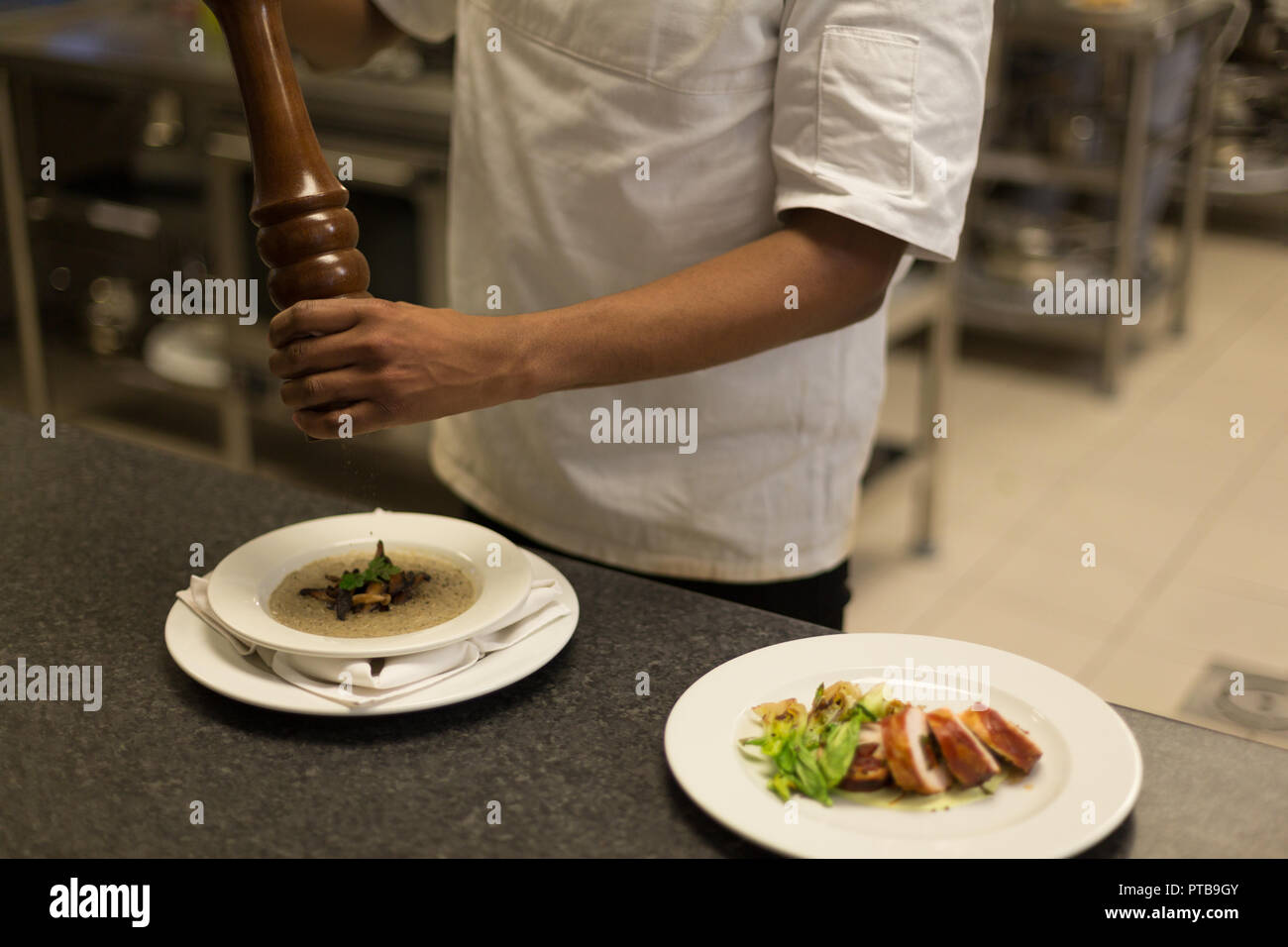 Chef cuisinier avec moulin à poivre dans la cuisine au restaurant Banque D'Images