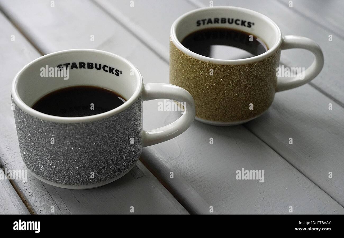 Deux tasses de café espresso Starbucks avec un cuir thème de Noël contenant à café expresso situer sur une table en lattes gris Banque D'Images