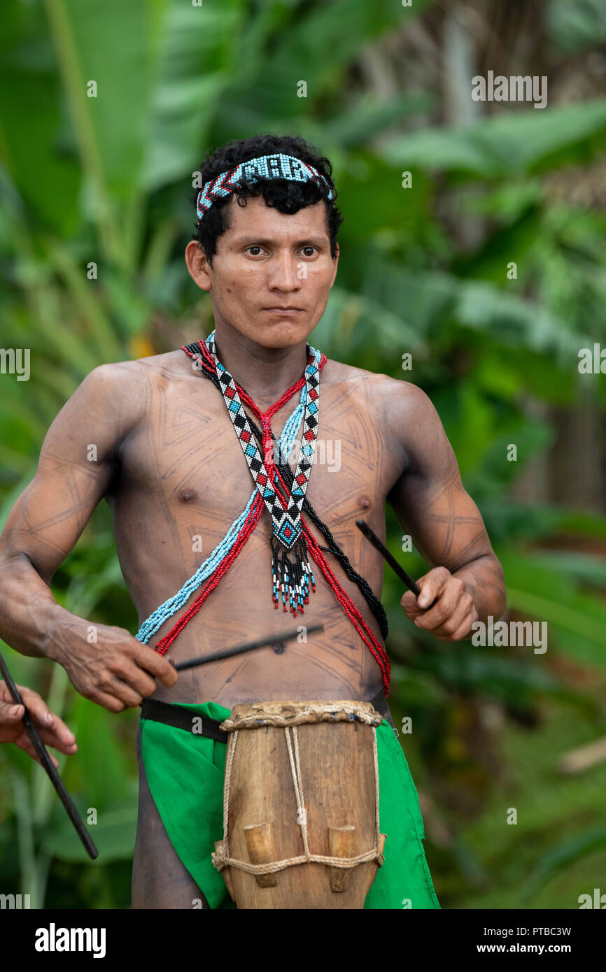 L'Amérique centrale, le Panama, le lac Gatun. Embera Indian village. Homme tatoué typique village Embera à jouer de la musique. Banque D'Images