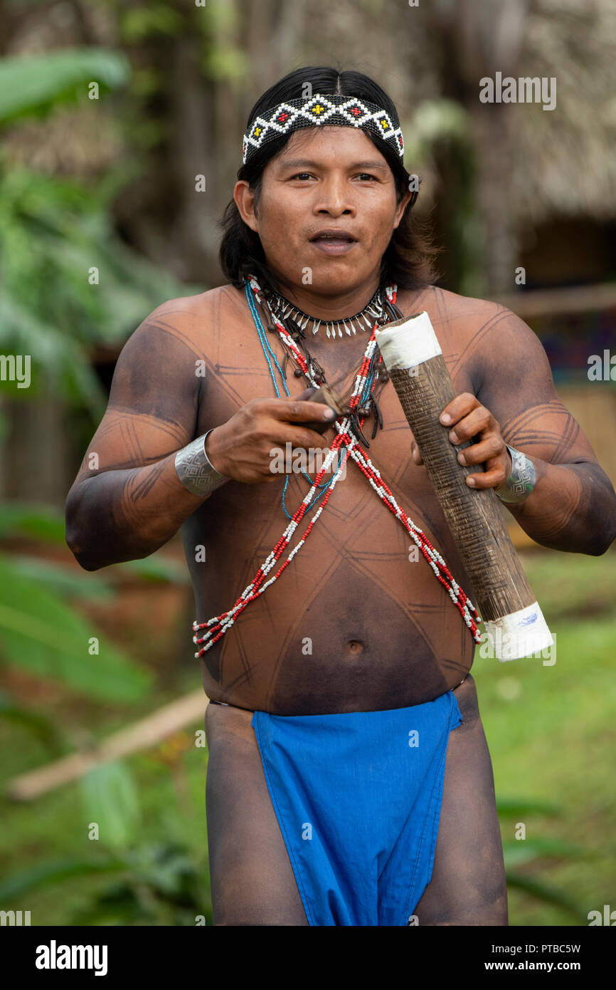L'Amérique centrale, le Panama, le lac Gatun. Embera Indian village. Homme tatoué typique village Embera à jouer de la musique. Banque D'Images