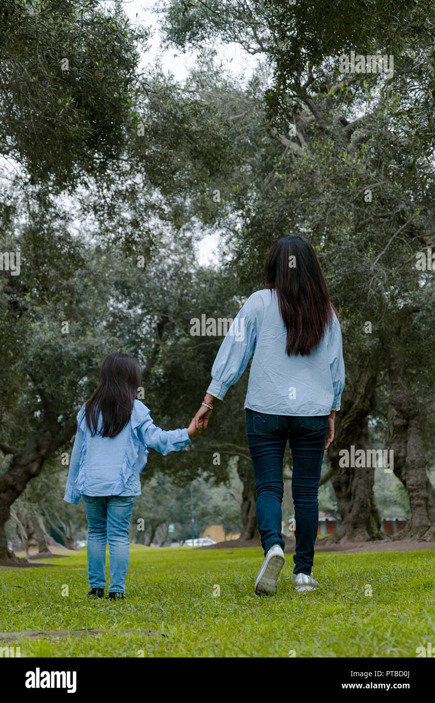 Mère et fille péruvienne peu marcher ensemble sur un après-midi d'automne, vu de l'arrière Banque D'Images