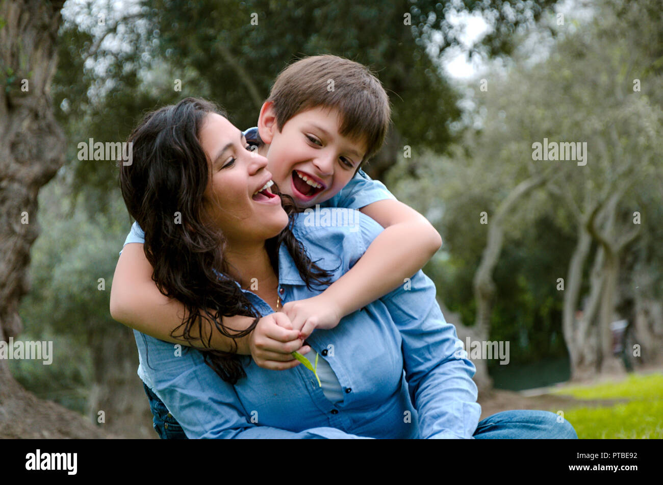 Serrant ses enfants mother smiling sur un après-midi d'automne dans le parc Banque D'Images