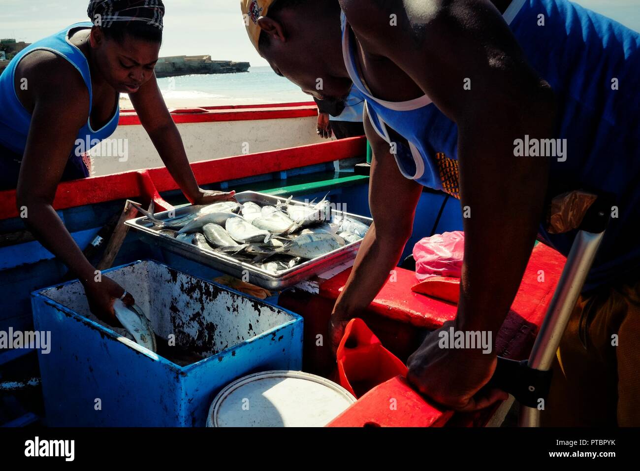 Vila do Maio, l'île de Maio, Cap-Vert - Jan 5 2016 : les pêcheurs de décharger ses prises pendant que la femme du marché va de l'avant pour vérifier sa Banque D'Images