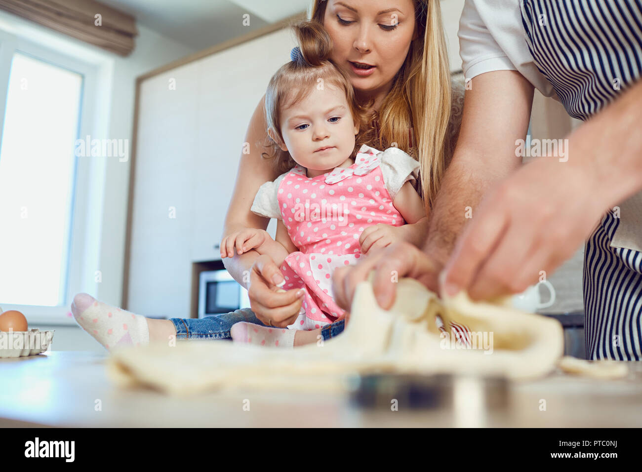 Un enfant avec sa mère prépare la pâte pour les cookies. Banque D'Images