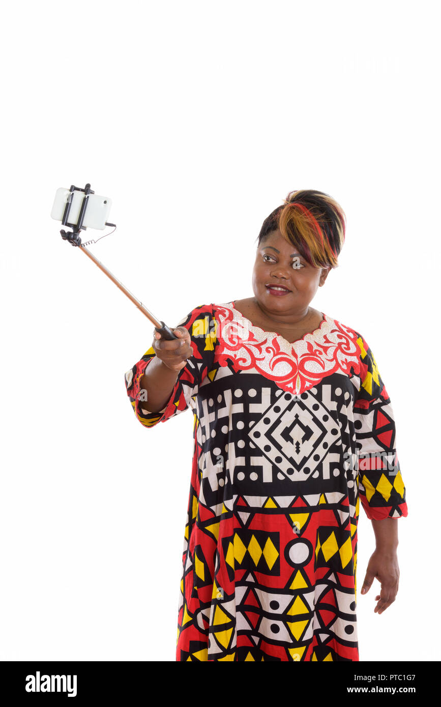 Studio shot of happy fat black African woman smiling while holdi Banque D'Images