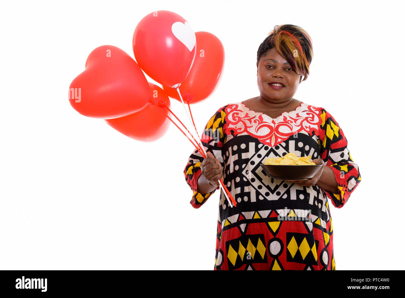 Happy fat black African woman smiling while holding bowl de la pota Banque D'Images