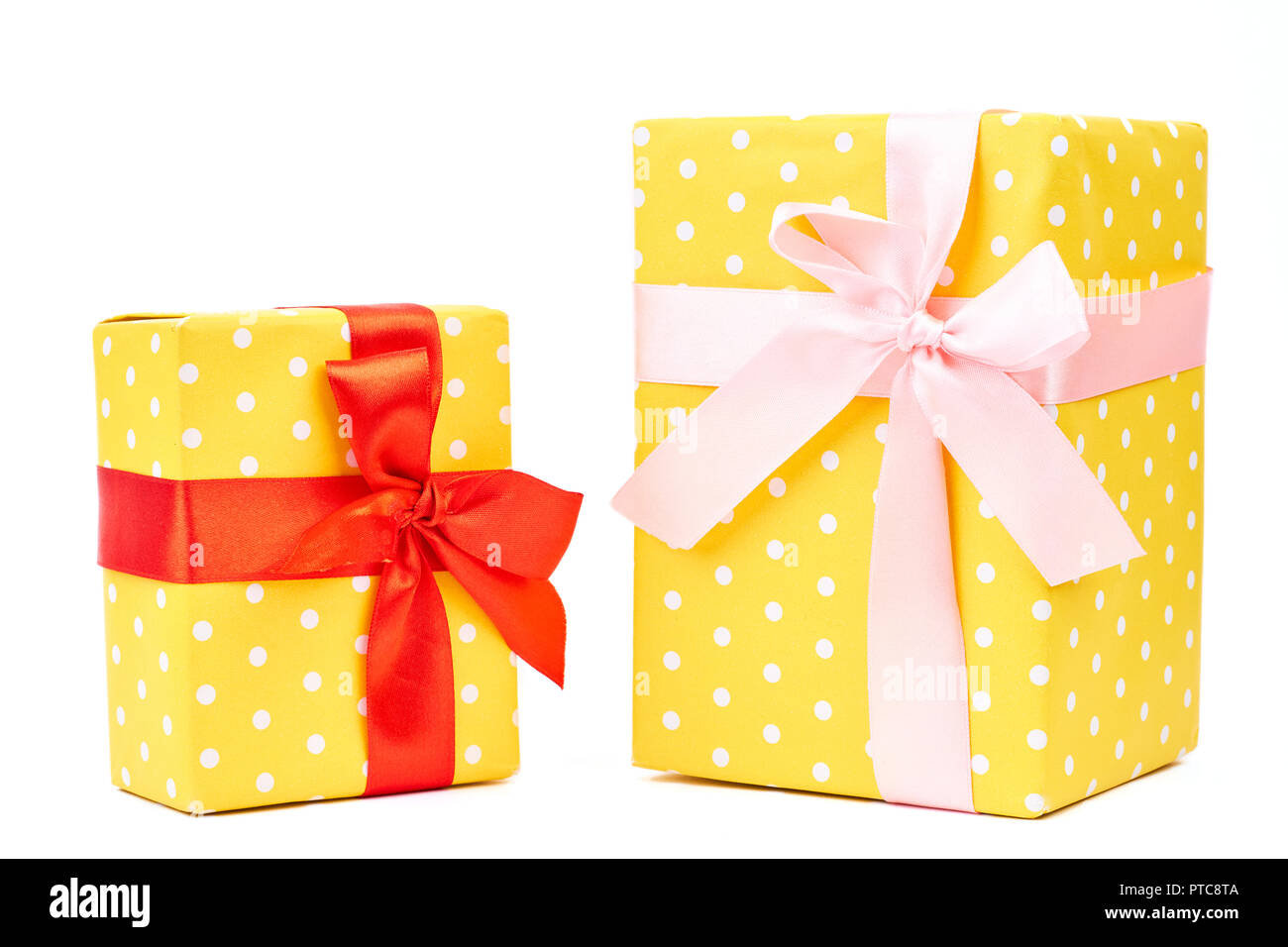 Cadeaux en pointillés jaune, fond blanc. Enveloppé dans du papier de soie à pois jaune et attachés à un ruban de satin. Paniers-cadeaux de Noël magnifiquement. Banque D'Images