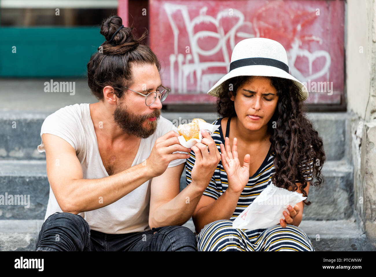 Paris, France - 30 août 2018 : Deux jeunes touristes assis manger donuts funny sur trottoir rue dehors en été journée à Florence, Tusca Banque D'Images