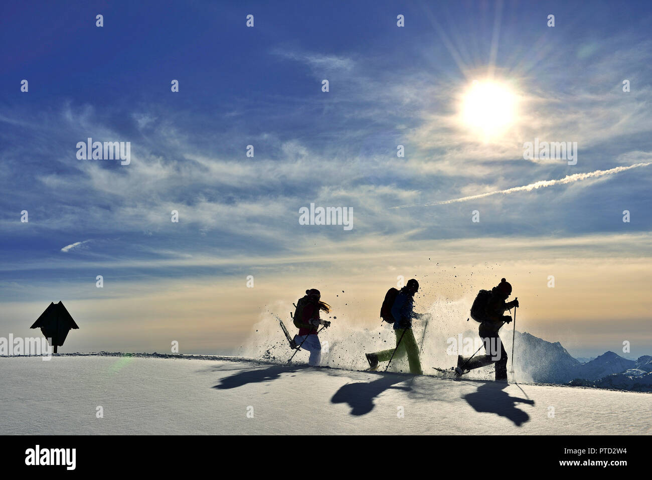 Trois randonneurs en raquettes courir dans la neige contre la lumière, le tour de l'Fellhorn, Reit im Winkl, Smiling, Portrait Banque D'Images