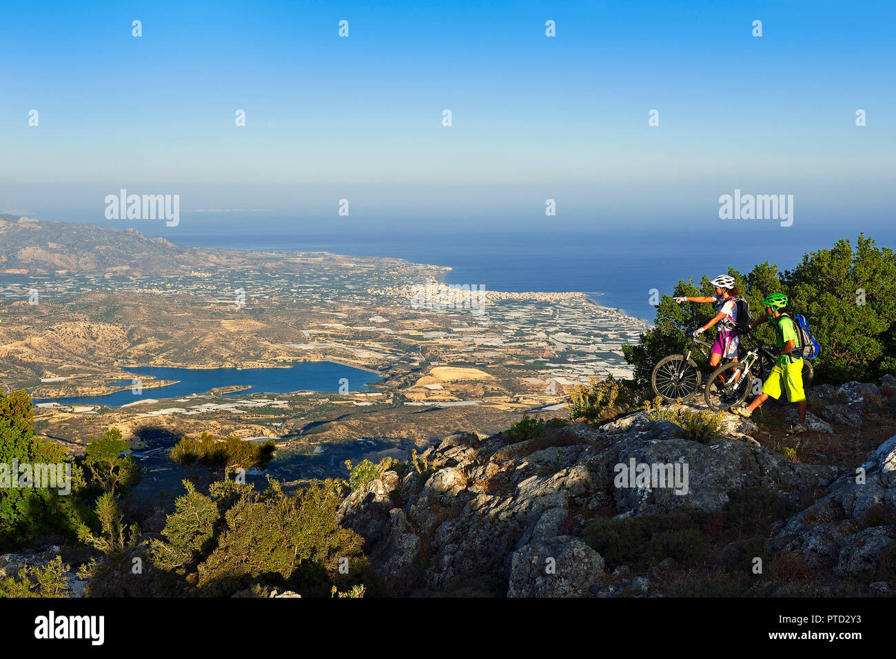 Deux vététistes se tenir sur un point d'observation en vue de Lerapetra, près de Stavros, Selakano, Crète, Grèce Banque D'Images