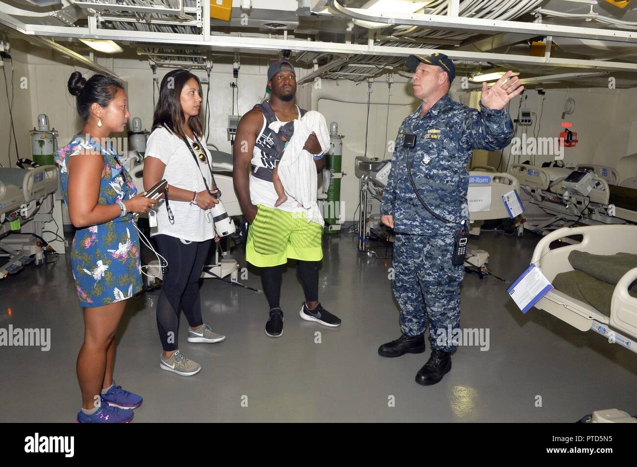 SAN DIEGO (11 juillet 2017), USS John P. Murtha (LPD 26) Commandant Le capitaine Kevin Parker donne une visite guidée de l'installation médicale du navire à Caroline panthère d'utiliser de nouveau Jonathan Stewart et sa famille. Stewart était en tournée le navire après avoir accueilli un camp de football des jeunes pour plus de 200 enfants de militaires de la base navale de San Diego. Banque D'Images