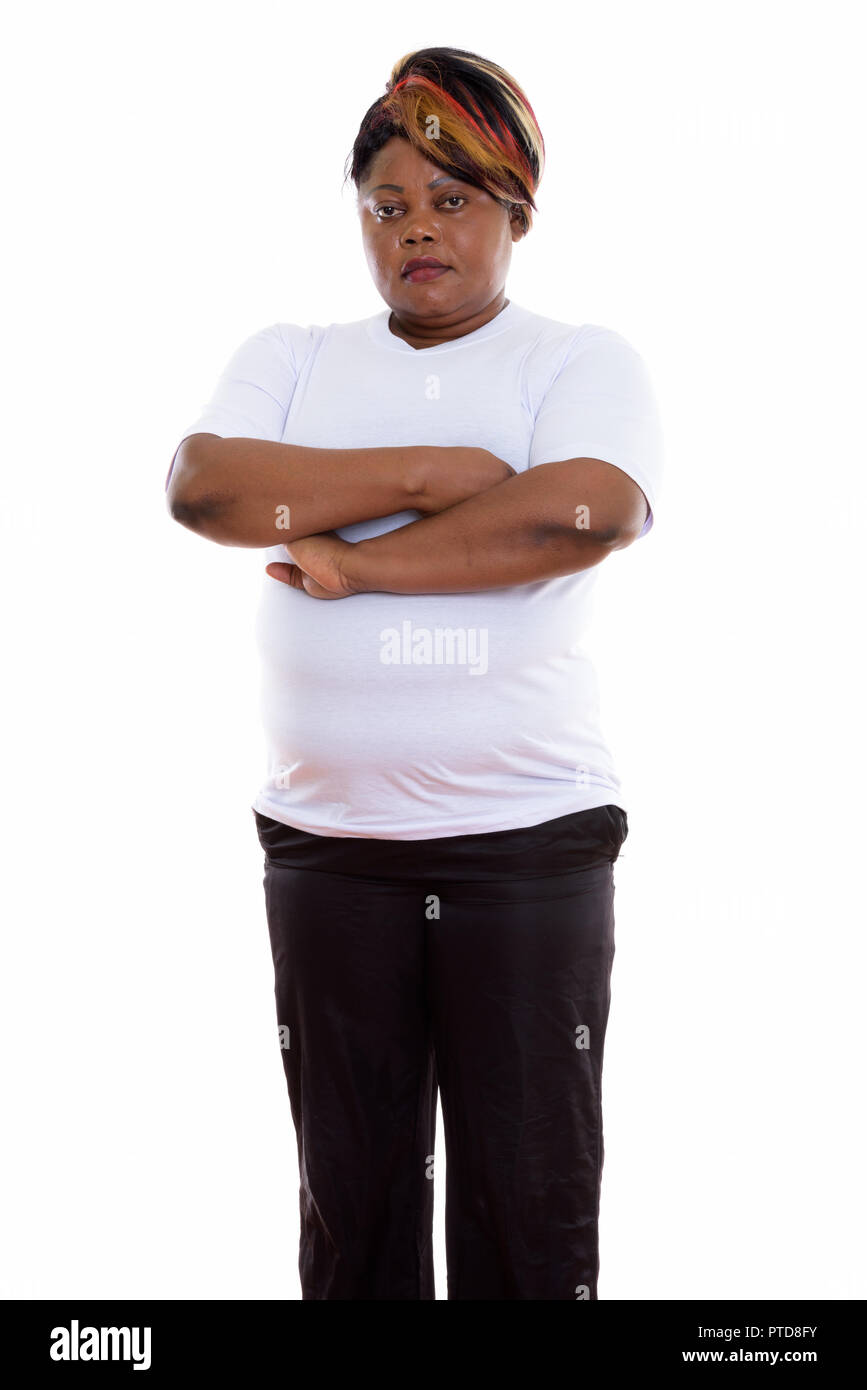 Studio shot of fat black African woman standing with arms crosse Banque D'Images