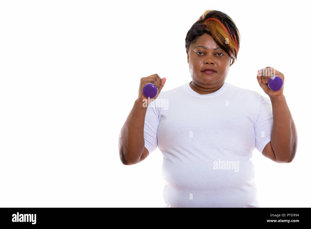 Studio shot of fat black African woman holding dumbbells prêt f Banque D'Images