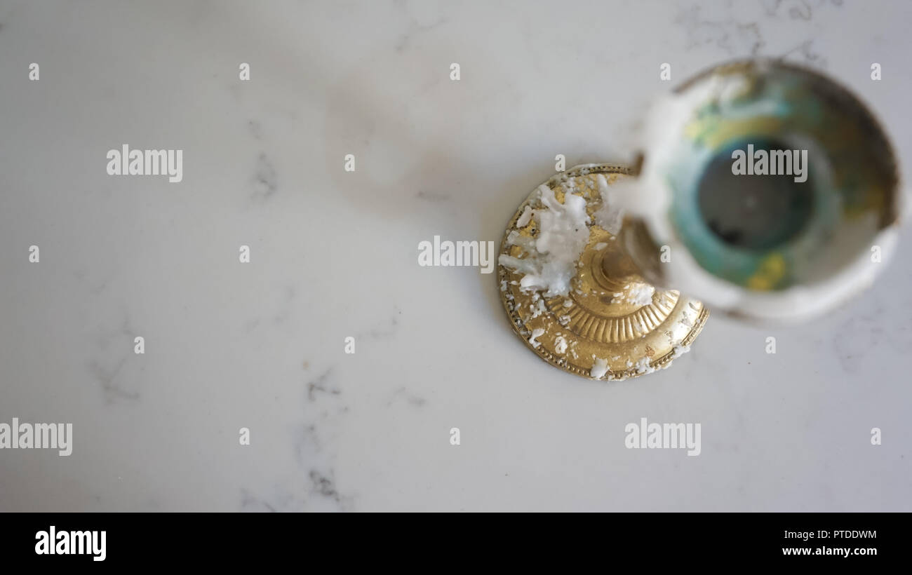 Close up de patine brillante, golden brass candle stick avec la cire qui s'écoule sur table de marbre (vue de dessus) avec chambre pour copier Banque D'Images