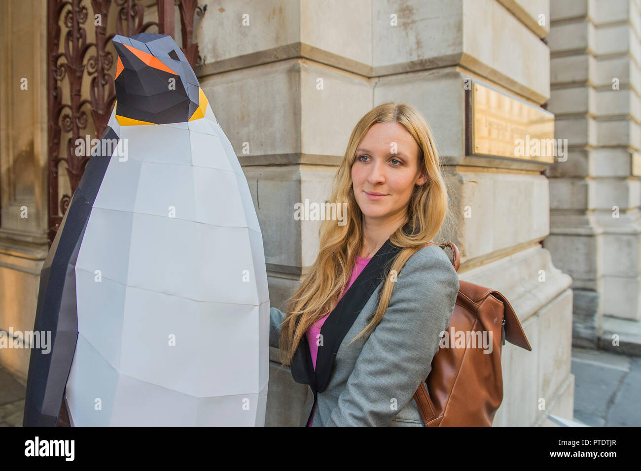 Londres, Royaume-Uni. 9 octobre, 2018. Un porte-parole de Greenpeace porte le pingouin dans à la sécurité - Gillian Anderson, ambassadeur de l'Antarctique Greenpeace, visite le Foreign & Commonwealth Office de remettre une pétition appelant à la création de la plus grande zone protégée sur la Terre - un 1,8 millions de kilomètres carrés de l'océan Antarctique Sanctuaire. Crédit : Guy Bell/Alamy Live News Banque D'Images