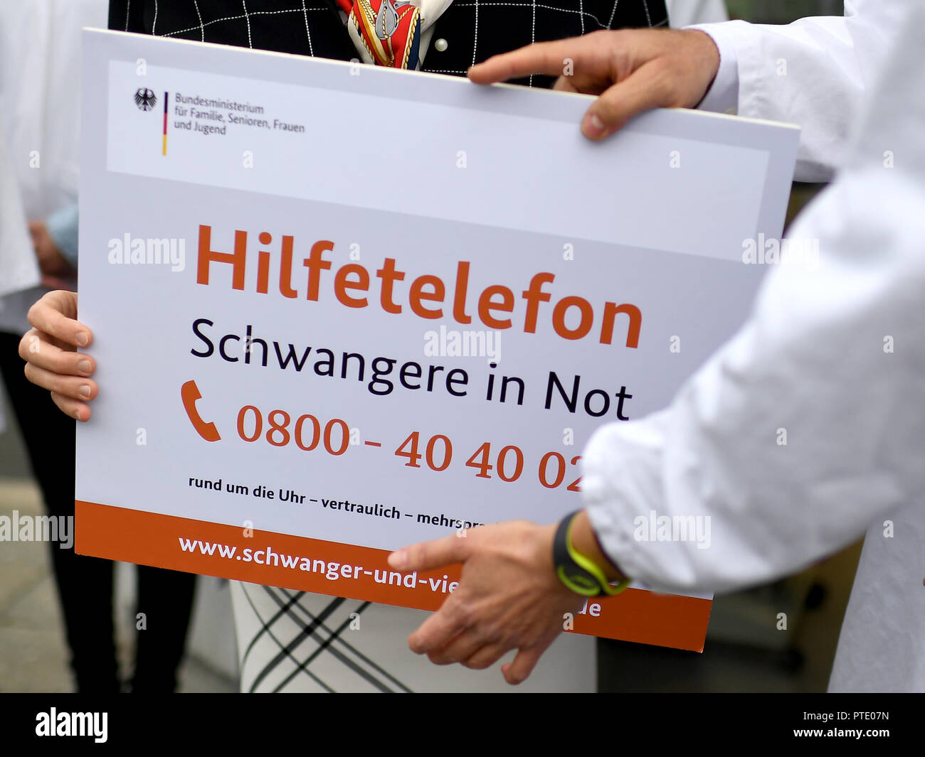 09 octobre 2018, Berlin : Franziska Giffey (SPD), Ministre fédéral de la famille, des personnes âgées, des femmes et des jeunes, et pharmacien Stolle sont titulaires d'un panneau publicitaire pour le téléphone d'aide pour les femmes enceintes dans le besoin' dans leurs mains. L'anonyme et offre une aide pour les femmes enceintes en situation de conflit. Photo : Britta Pedersen/dpa-Zentralbild/dpa Banque D'Images