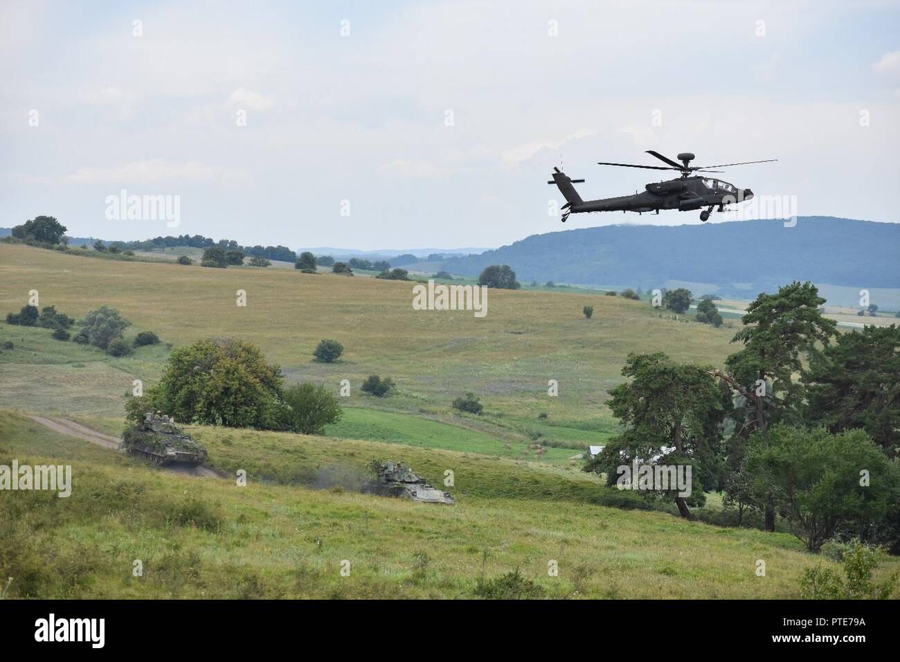 Les hélicoptères Apache AH-64 feu sur des cibles comme M2A1 des véhicules de combat Bradley se mettent en position dans le cadre de Getica 17 Sabre. La ferme château 17 projets directement à soutenir de telles évaluations par la construction d'un centre de formation national commun, la Roumanie, de l'infrastructure nécessaire à la formation des équipages d'armure. Les deux tombent dans le cadre de l'opération Atlantic résoudre, un effort pour rassurer les partenaires de l'OTAN de l'engagement des États-Unis à l'alliance et de décourager les menaces régionales. Banque D'Images