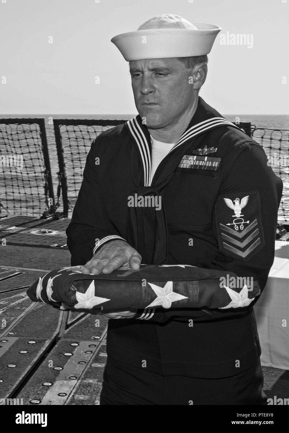 Mer Méditerranée (16 juillet 2017) Technicien Sonar (Surface) 1re classe Travis Daniels porte l'enseigne pendant un enterrement en mer à bord de la cérémonie missiles USS Truxtun (DDG 103). Truxtun, partie de la George H. W. Groupe aéronaval du Bush (GHWBCSG), mène des opérations navales dans la sixième flotte américaine zone d'opérations à l'appui de la sécurité nationale des États-Unis en Europe et en Afrique. Banque D'Images