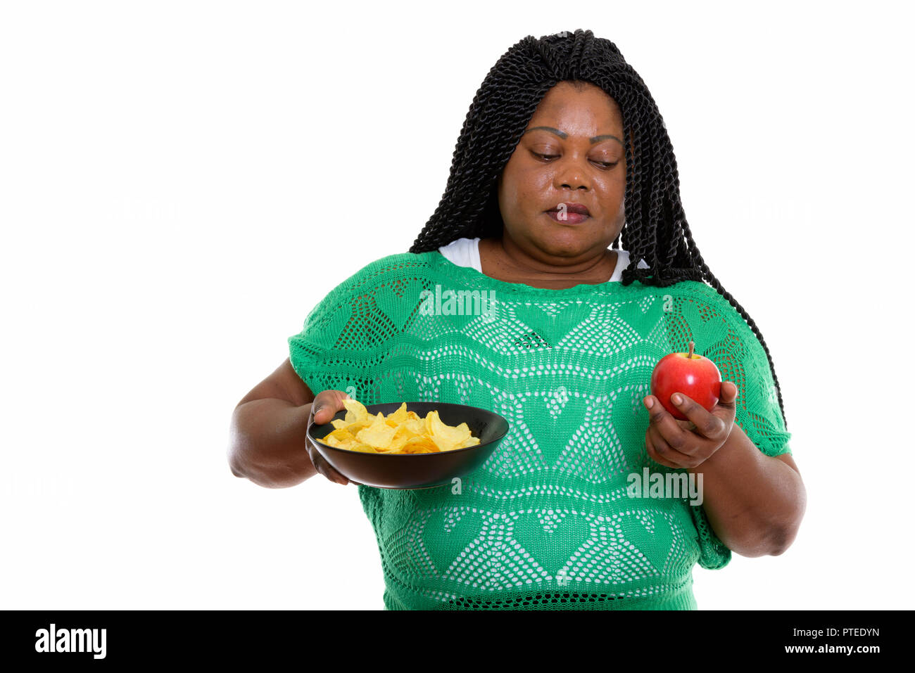 Studio shot of fat black African woman holding bowl of potato ch Banque D'Images