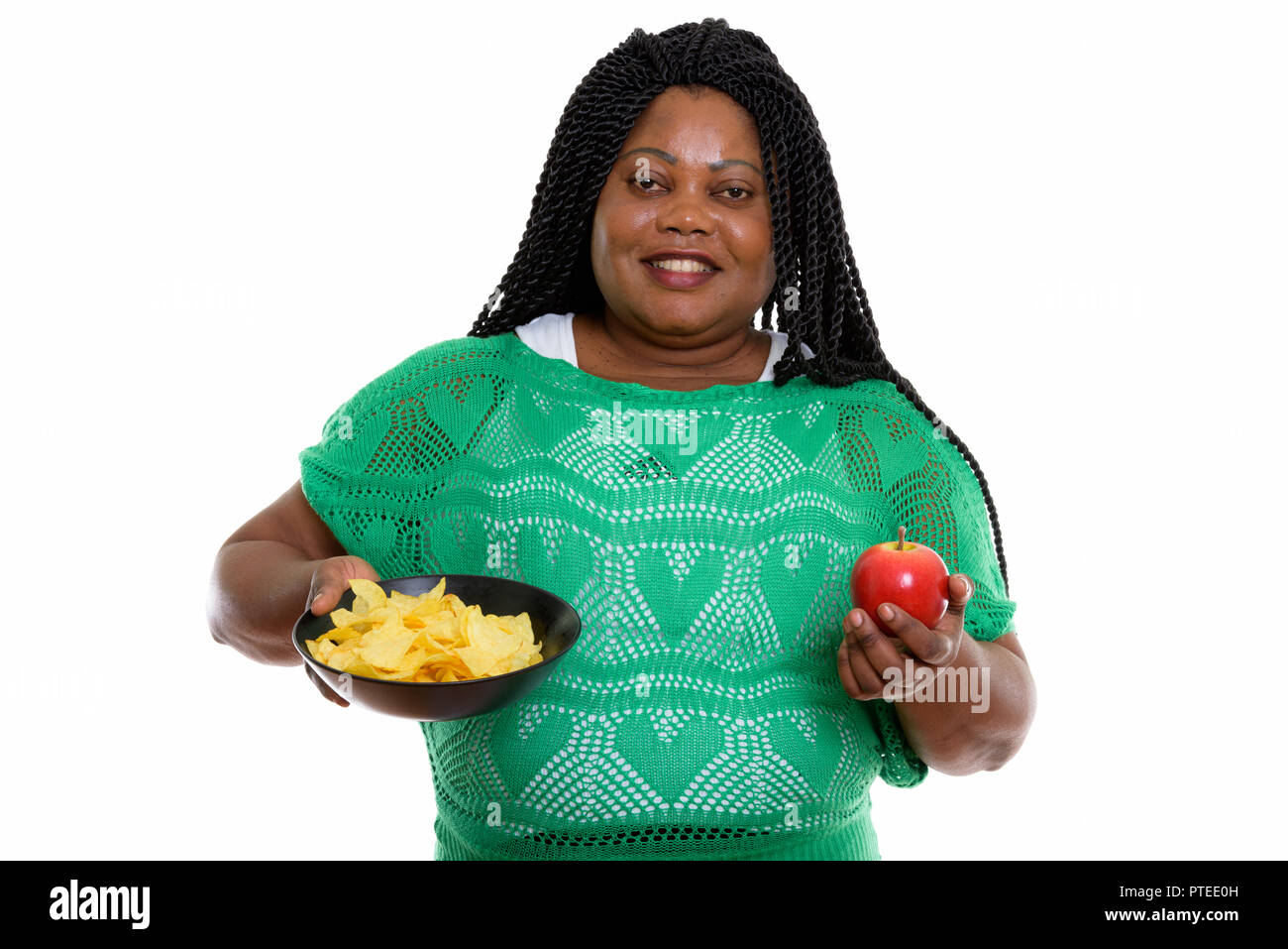 Studio shot of happy fat black African woman smiling while holdi Banque D'Images