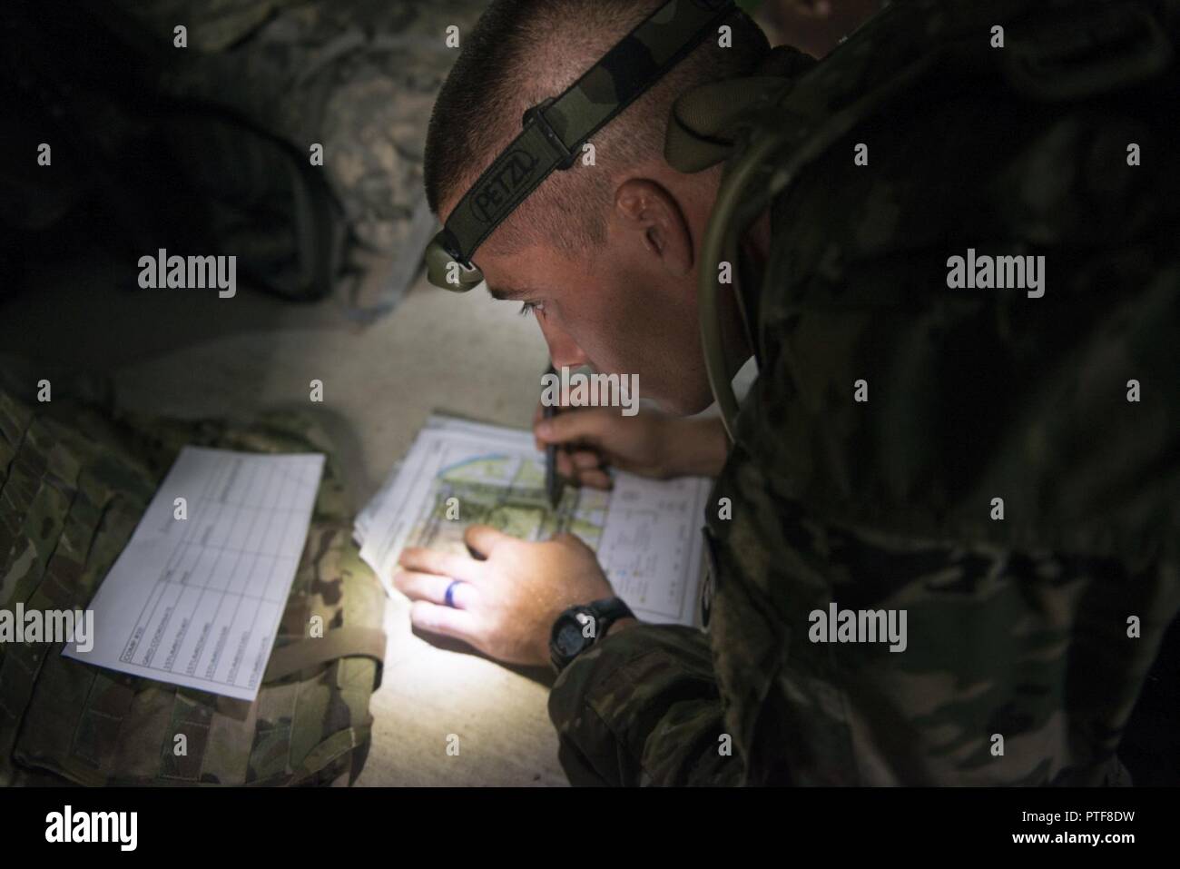 Le s.. Dustin Rottero, un recruteur avec Virginia Army National Guard, bataillon de recrutement et de maintien de l'Illinois de la Garde nationale, ses parcelles de points pour l'heure de la navigation terrestre pendant l'Army National Guard 2017 Concours meilleur guerrier le 19 juillet 2017, à Camp Ripley, Minn. concurrents terminé un événement de navigation de nuit où ils avaient de trouver trois points en deux heures avant l'heure de la navigation terrestre événement où ils devaient trouver cinq points en trois heures. (La Garde nationale du Minnesota Banque D'Images