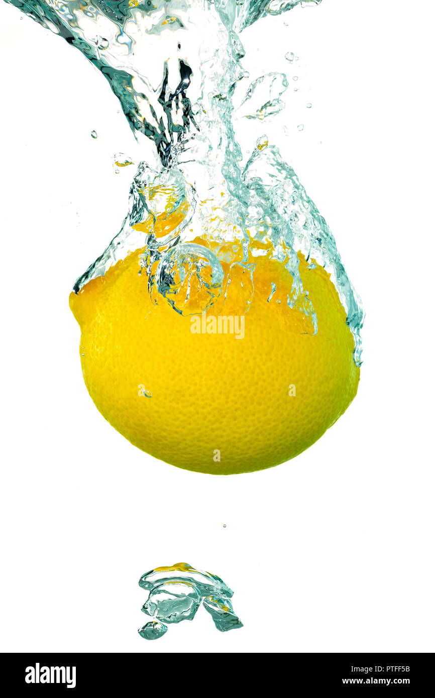 Une seule projection de citron dans l'eau avec des bulles d'air Banque D'Images