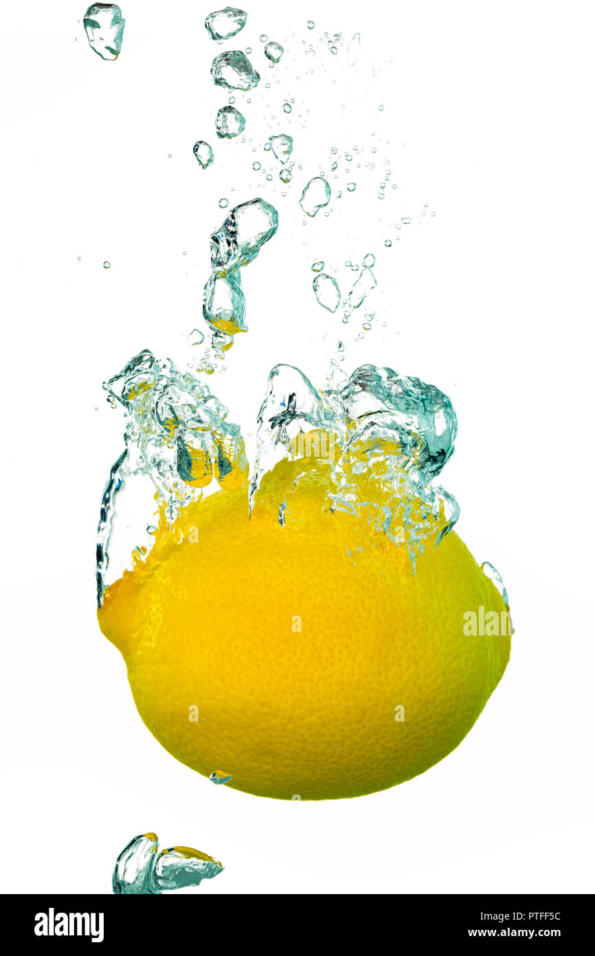 Une seule projection de citron dans l'eau avec des bulles d'air Banque D'Images