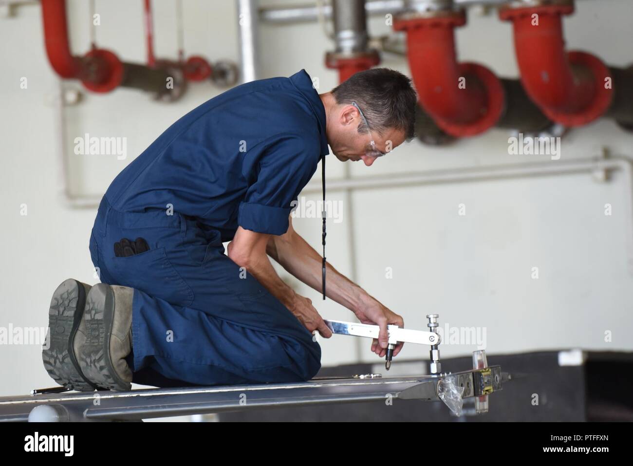 U.S. Air Force Tech. Le Sgt. William Wright, technicien de maintenance, carburant affecté à la 140e Escadre, Colorado Air National Guard, utilise un J-bar pour desserrer les vis sur l'aile d'un F-16 Falcon pendant une phase d'inspection, à Kadena Air Base, Okinawa, Japon, Juillet 10, 2017. Wright soutient le théâtre Security Package, une formation systématique responsable d'aider à maintenir la stabilité et la sécurité dans la région du Pacifique. Banque D'Images