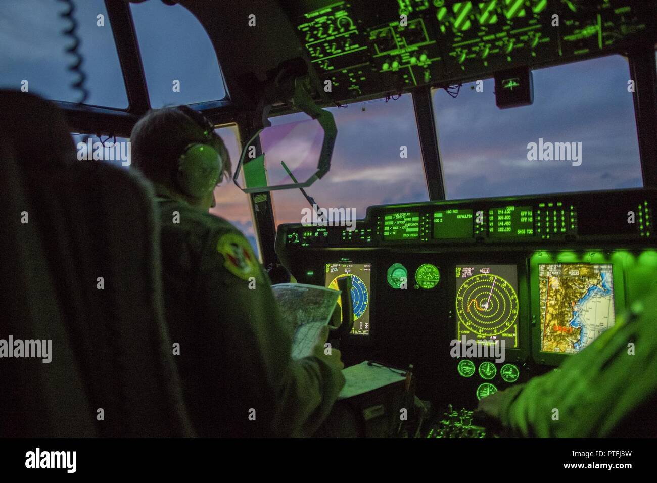 Un C-130J Super Hercules pilote avec le 36e Escadron de transport aérien, vérifie les itinéraires de voyage au cours d'une mission d'entraînement de routine, le 18 juillet 2017, au cours de la zone métropolitaine de Tokyo, Japon. La routine de formation incluse, de vol à basse altitude des cargaisons lourdes simulé et chute des opérations de nuit y compris le chargement et le déchargement de l'aéronef. Banque D'Images