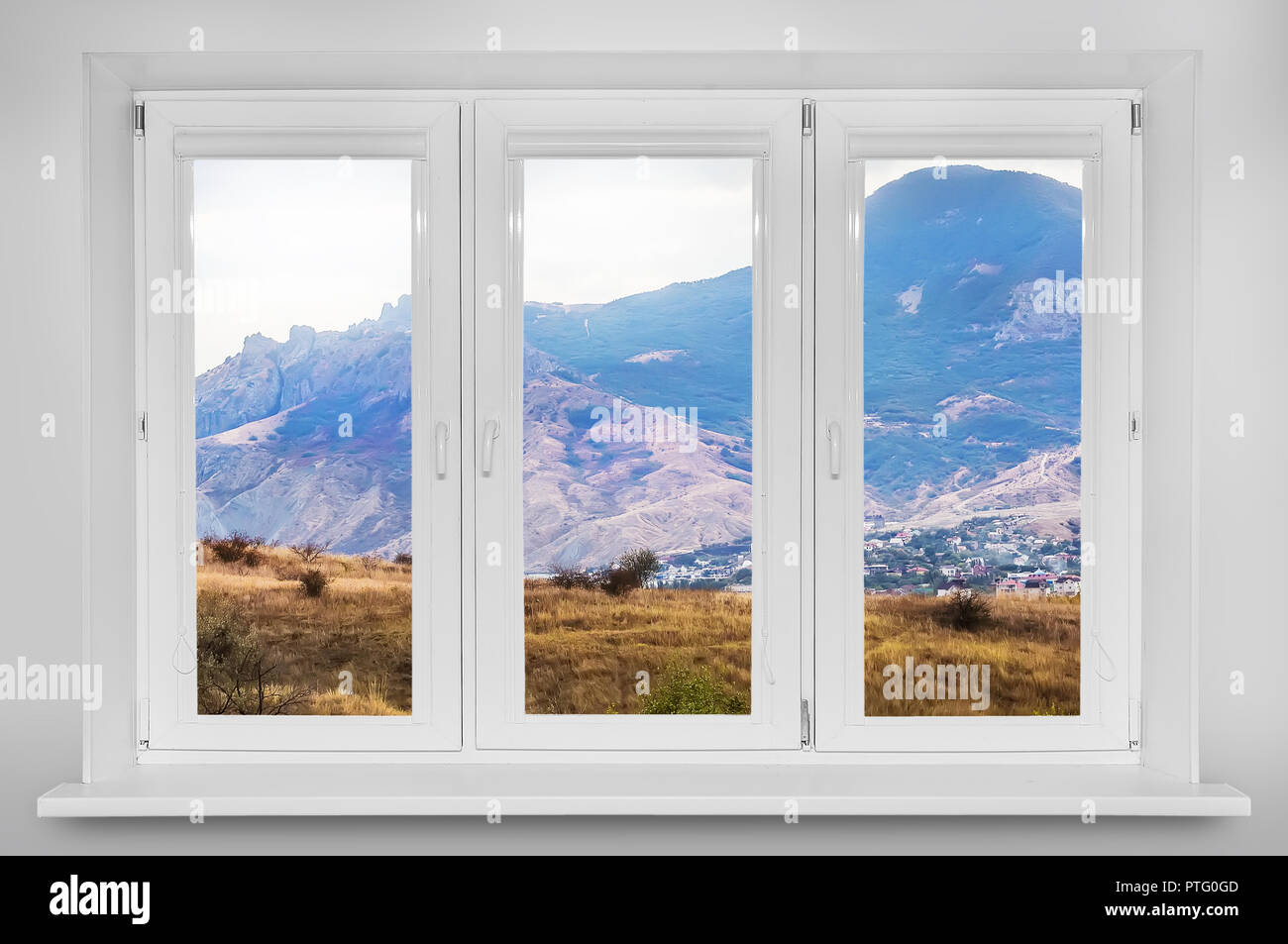 Vue de la fenêtre. Paysage de forêts de montagne sous ciel avec nuages dans la lumière du soleil Banque D'Images