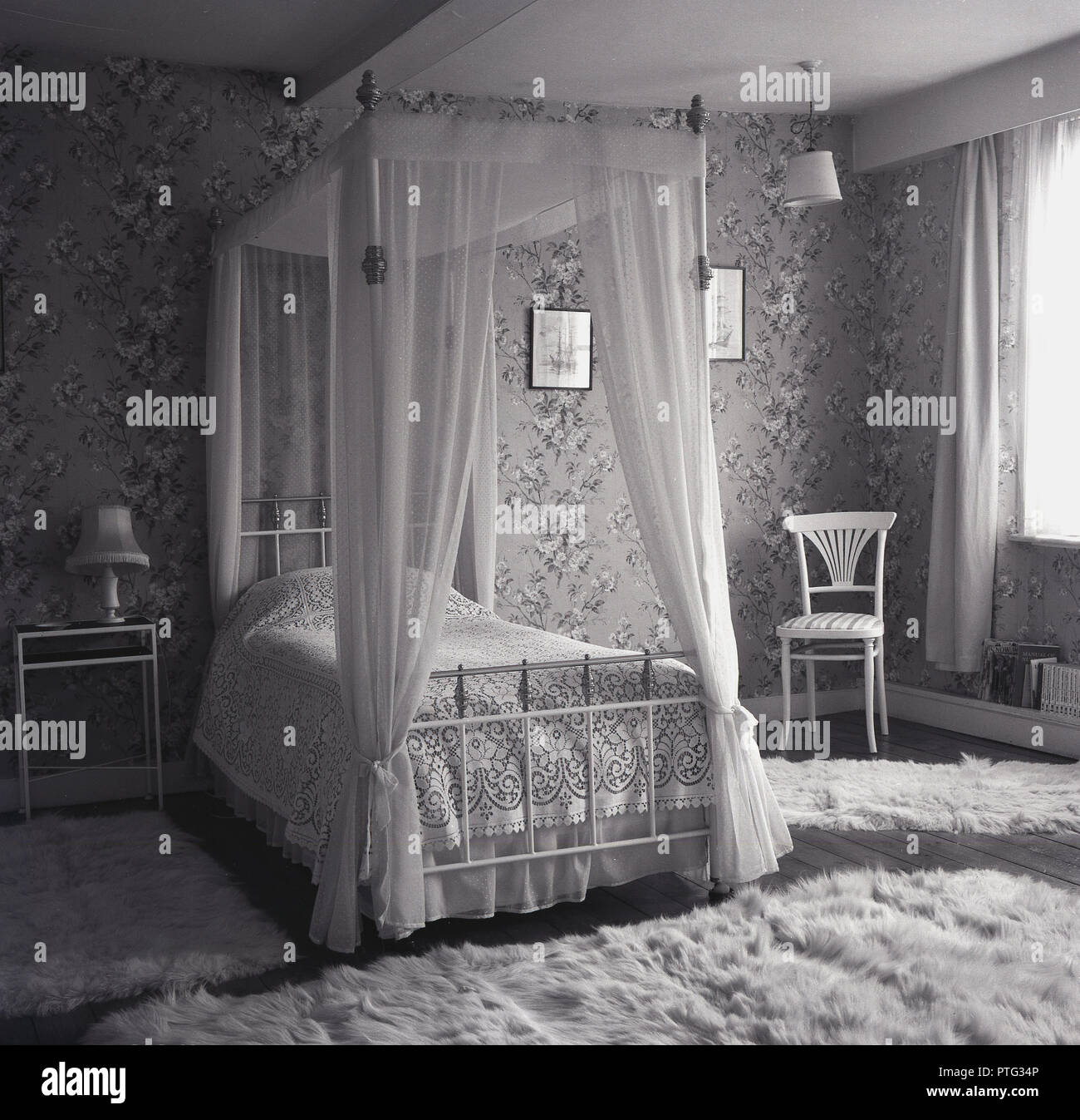 Années 1960, quatre affiches, seul metal lit dans la chambre de luxe individuelle avec shag laine tapis à poils sur plancher en bois, England, UK. Banque D'Images Années 1960, quatre affiches, seul metal lit dans la chambre de luxe individuelle avec shag laine tapis à poils sur plancher en bois, England, UK. Banque D'Images