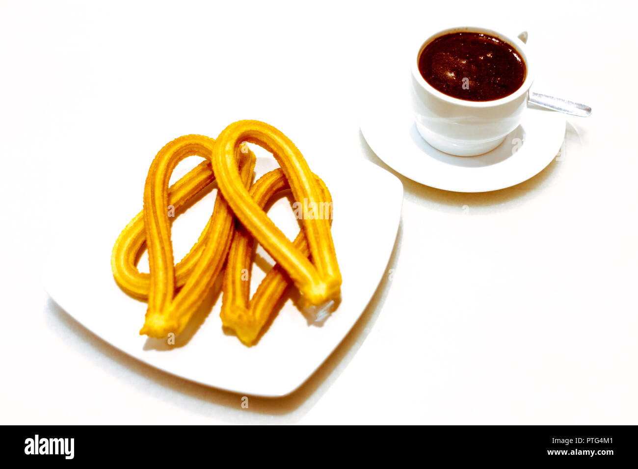 Churros et chocolat petit déjeuner traditionnel espagnol sur une plaque sur fond blanc Banque D'Images