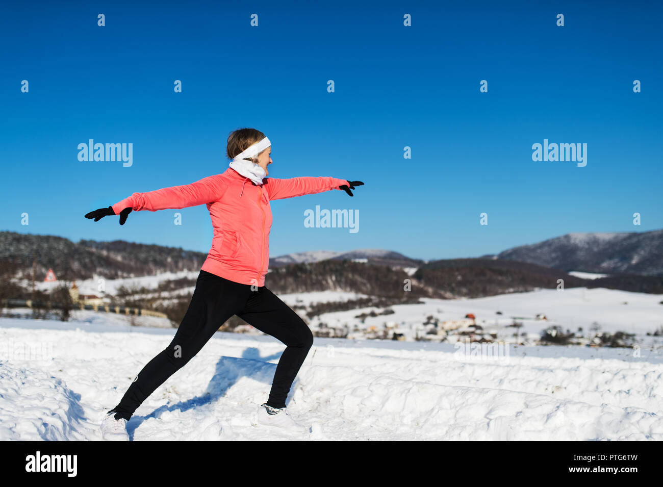 Senior woman runner stretching en hiver la nature. Copier l'espace. Banque D'Images