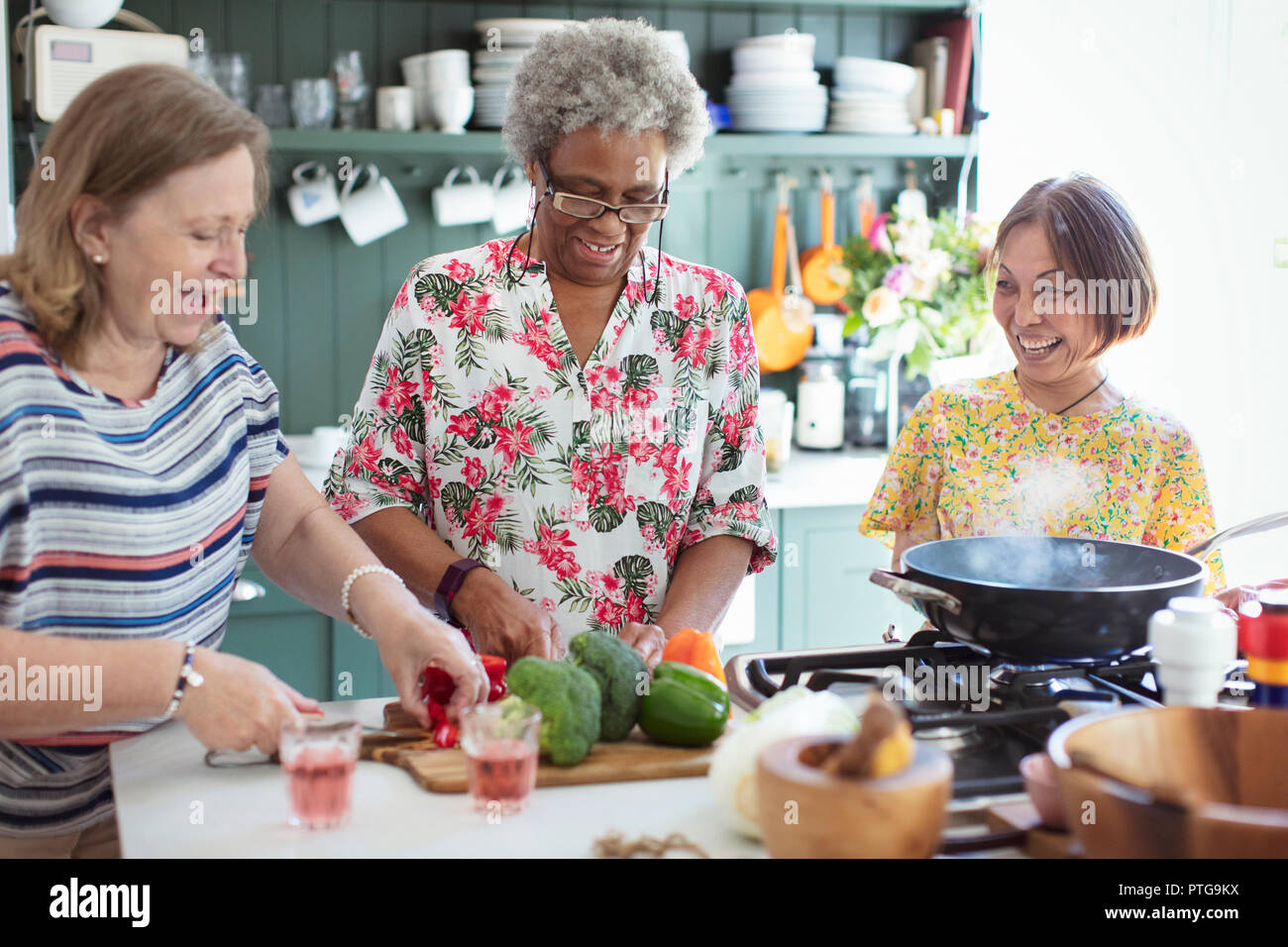 Les femmes âgées amis cooking in kitchen Banque D'Images