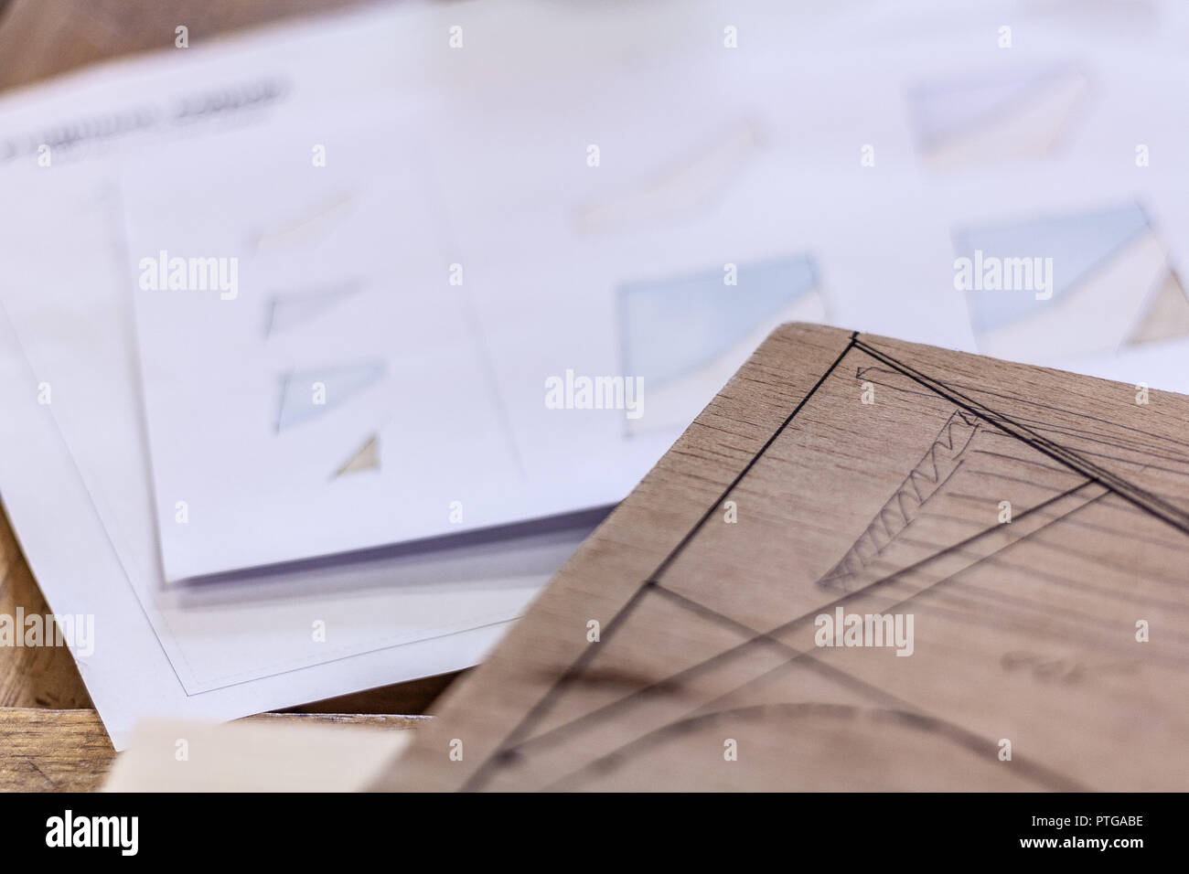 L'éco-friendly tanneur's shop. Détails et se concentrer sur les esquisses du projet, de la sciure et des raboteuses ou ciseaux, tout en jambes pour une table de l'écrou. Banque D'Images