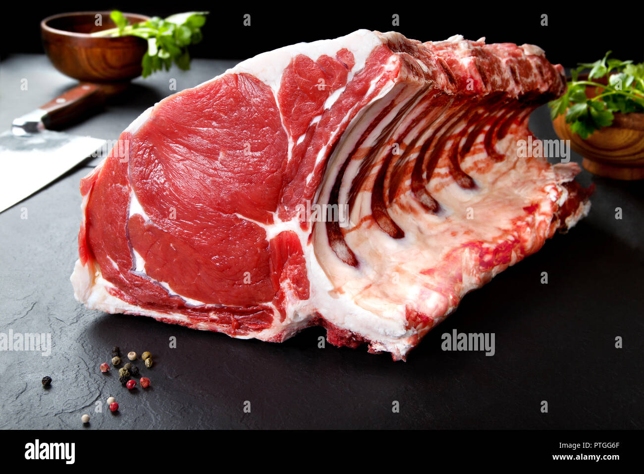 Nature morte des côtes de porc fraîches et crues et des côtelettes de porc. Steak de viande pour la cuisson sur fond noir. Boucherie. Banque D'Images