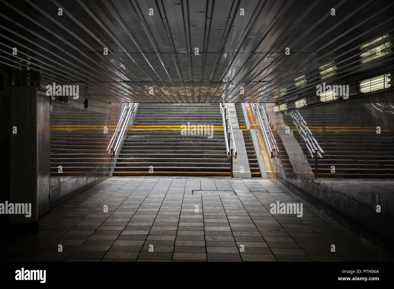 La lumière du soleil tombe sur l'escalier à la sortie d'un passage inférieur de la rue dans le tunnel. Banque D'Images
