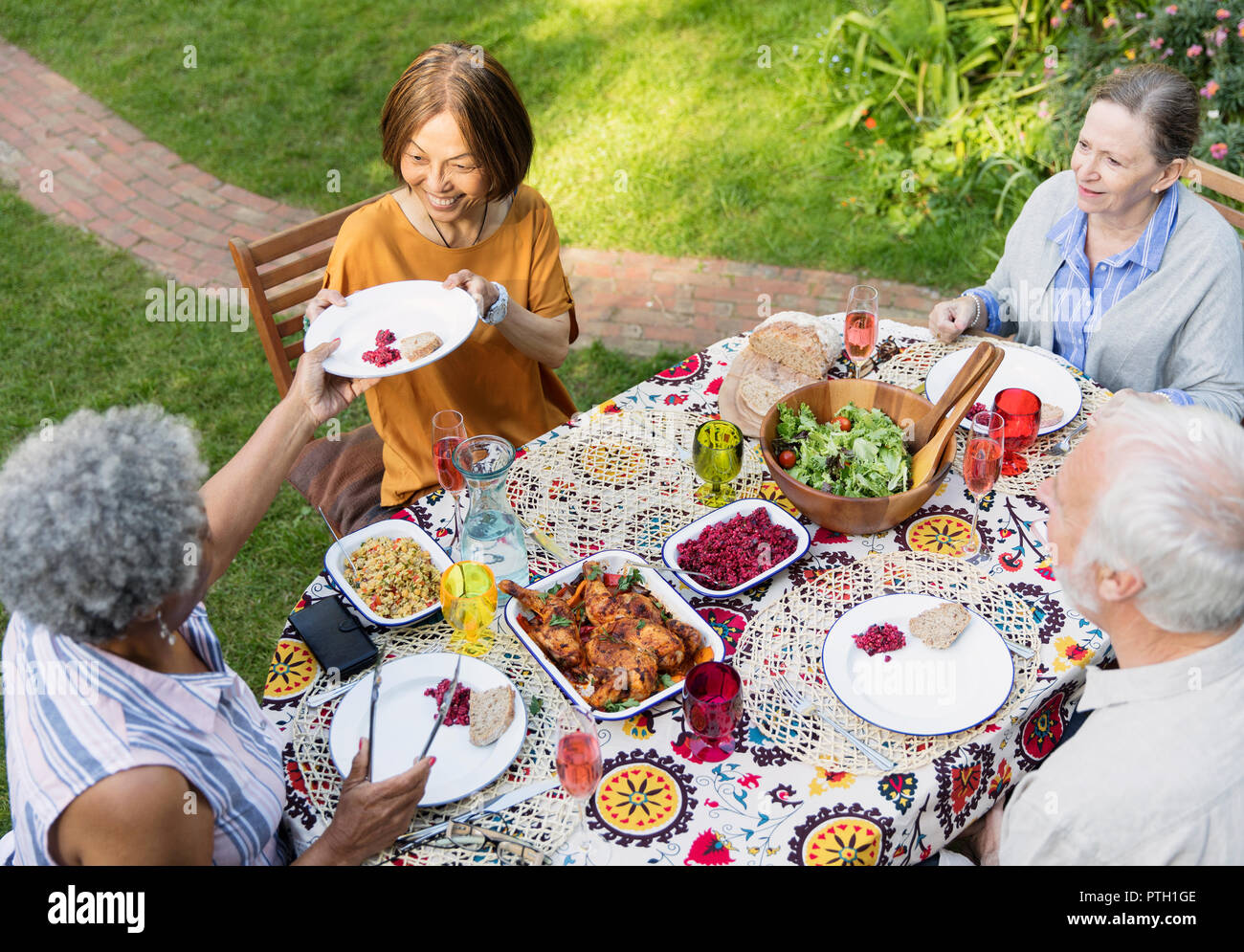 Senior friends enjoying déjeuner à table patio Banque D'Images
