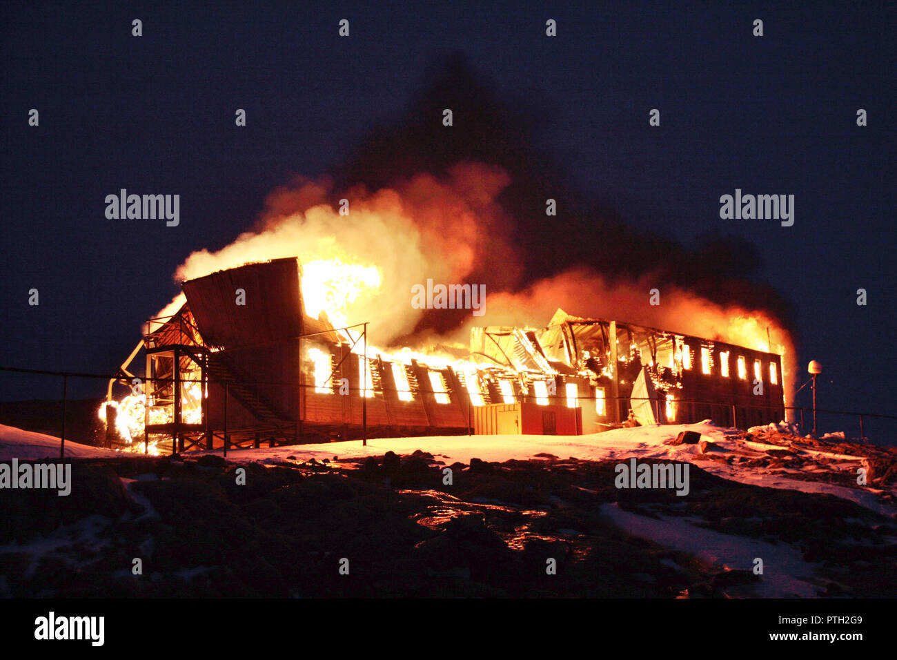 Vieux bâtiment en bois, de la station polaire, mis le feu pour la dépose. L'incendie. La nuit. Corbeille. L'antarctique. Banque D'Images