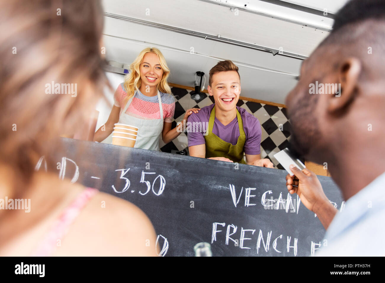 Les clients de donner carte de crédit au vendeur de camion alimentaire Banque D'Images